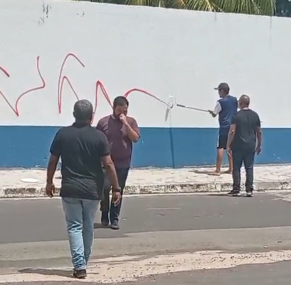 Assista! Homem picha muro de escola, é capturado pela polícia e acaba pintando o local pichado